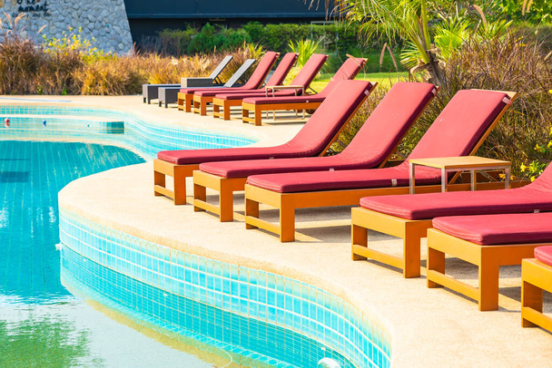 Belle chaise vide autour de la piscine extérieure dans la station hôtelière pour des vacances de voyage - Photo, image