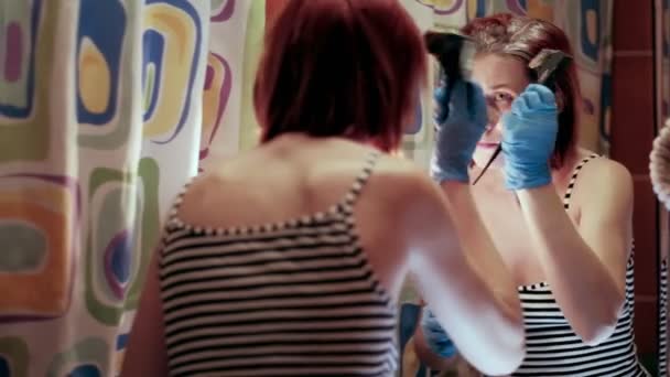 自己分離中の女性の美容師は、オレンジで彼女の頭の上に彼女の髪を染料。4k - 映像、動画