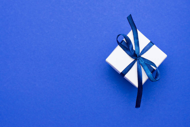 Caja de regalo con lazo tonificado en azul clásico. Color del año 2020. Copiar espacio
. - Foto, imagen