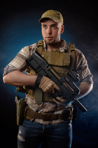 Ein Militärangehöriger in kugelsicherer Weste mit automatischem Gewehr - Foto, Bild
