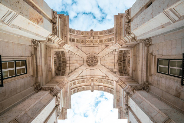 ルア・オーガスタ凱旋門の詳細｜ポルトガルのリスボン市の歴史的中心部にあります。雲と青空。道路からの眺め. - 写真・画像