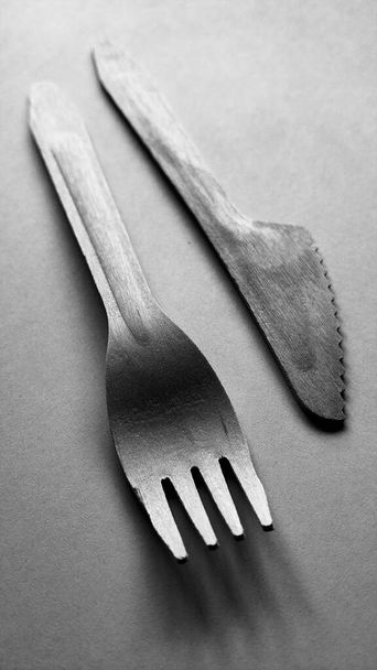 Kontrast plastik i bambus drewniany widelec i nóż czarno-biały. Ekologiczne jednorazowe sztućce - Zdjęcie, obraz
