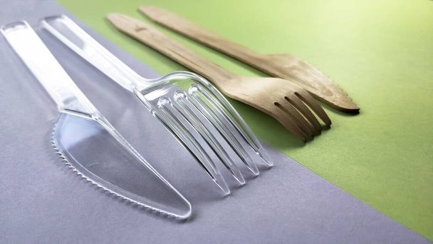 Kontrastní plastová a bambusová dřevěná vidlička a nůž. Šetrné k životnímu prostředí jednorázové příbory - Fotografie, Obrázek