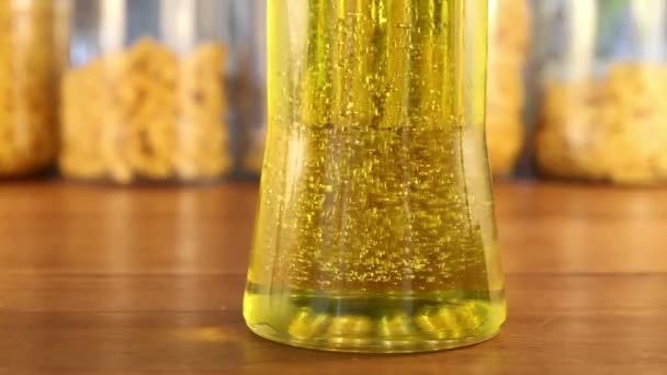 Złoty pęcherzyki zmienić kierunek w słoiku oliwy z oliwek - Materiał filmowy, wideo
