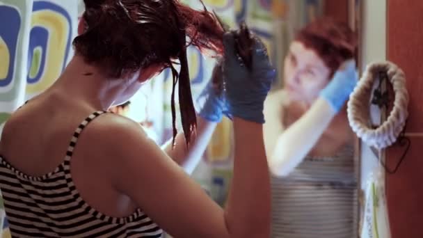 Női fodrász az elszigeteltség alatt narancssárgára festi a haját a fején. 4k - Felvétel, videó