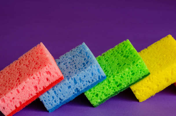 Kitchen sponges on a lilac background. Set of multi-colored kitchen sponges. Home routine and commercial cleaning company. Selective focus. - Fotó, kép
