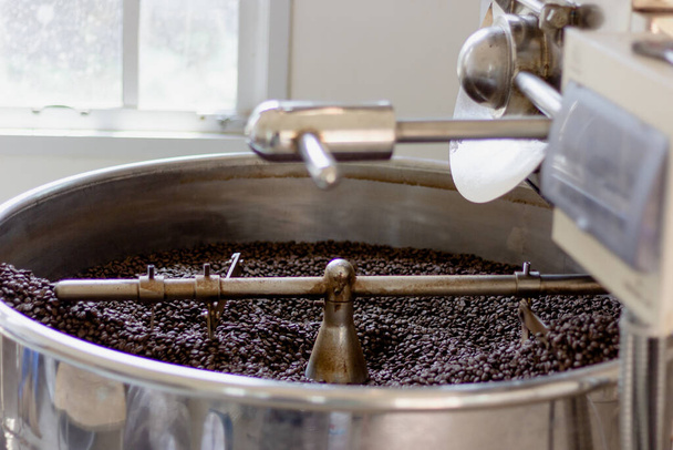 Granos de café frescos en máquina profesional tostadora de café en fábrica
 - Foto, Imagen
