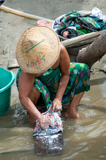 Nehir kıyısında hayat, insanlar giysilerini yıkar.. - Fotoğraf, Görsel