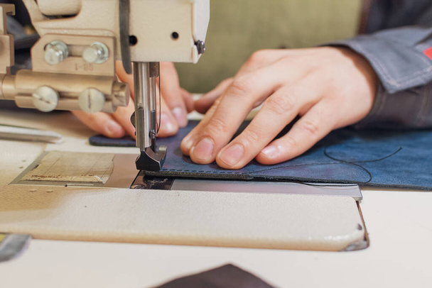 mains d'une couturière tailleur au travail dans l'atelier pour une machine à coudre industrielle, la production de vêtements, métier à tisser gros plan
 - Photo, image