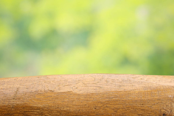Tapa de mesa de madera vacía en borroso verde abstracto del jardín y la casa en el fondo de la mañana
. - Foto, imagen