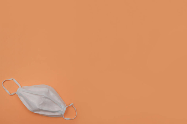 Хирургическая маска для лица на оранжевом фоне с большим текстовым пространством - Фото, изображение