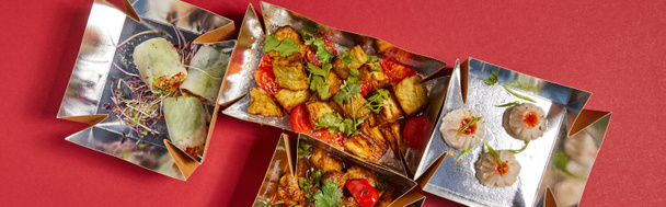 panoramic crop of delicious chinese food in takeaway boxes on red  - Photo, Image