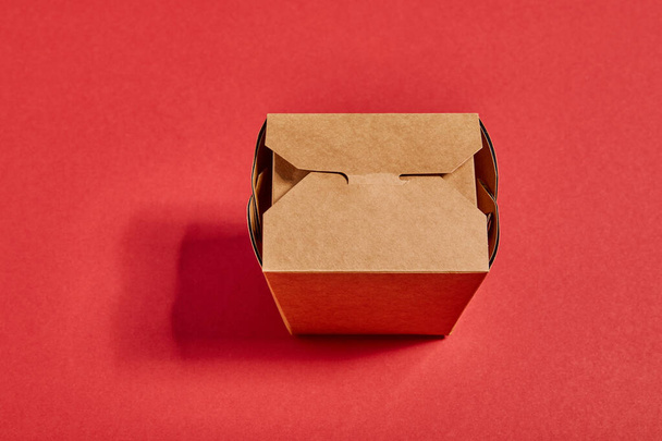 top view of carton takeaway box on red - Foto, Imagen