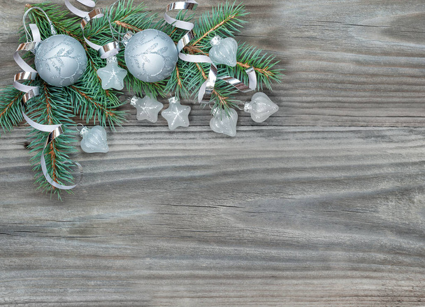 Kompozycja bożonarodzeniowa z zielonymi gałązkami jodły i srebrnymi dekoracjami na drewnianym tle, życzenie przestrzeń-kopiarka - Zdjęcie, obraz