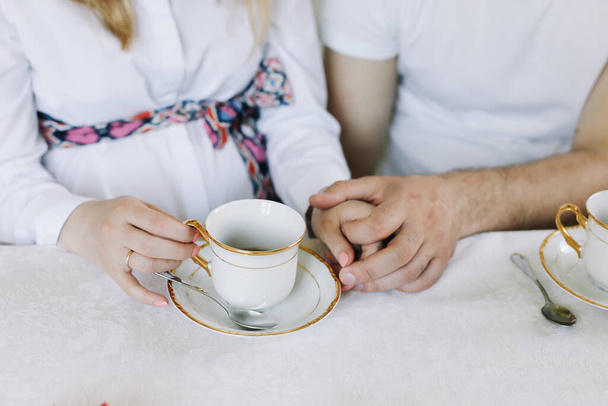Hands of happy couple drinking hot tea at home. Happy family lunch concept. hands of lovers drinking tea. breakfast at home  - Фото, зображення