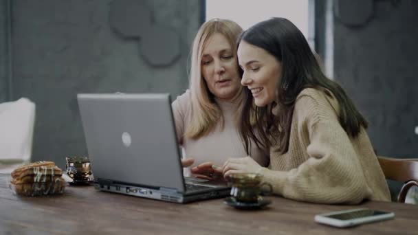 Una figlia insegna a sua madre come utilizzare un computer portatile per lo shopping online
. - Filmati, video
