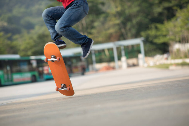 view on Skateboarder legs, skateboarding and tricks at outdoors - Фото, изображение
