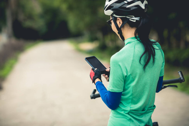 Cyclist use smartphone for navigation when riding mountain bike on forest trail - Foto, Bild