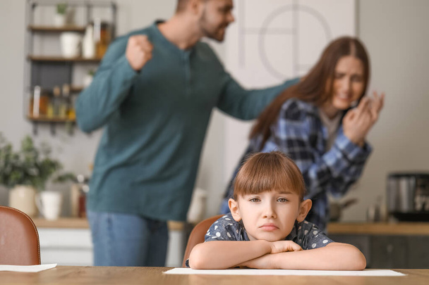 Sad little girl and her quarreling parents at home - Valokuva, kuva