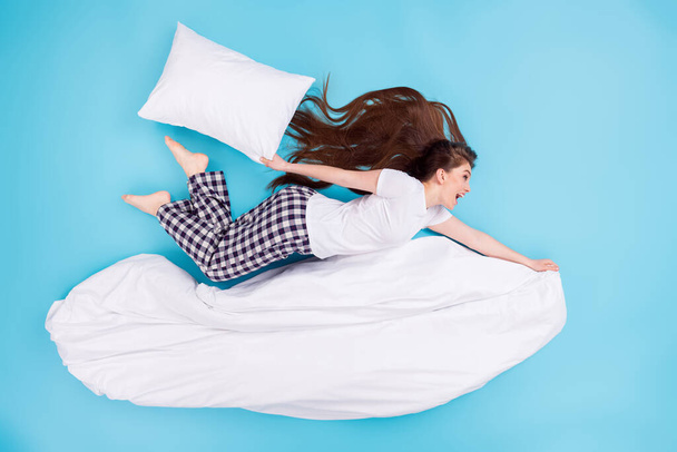 Full length high angle top above flat lay view photo of funky pretty lady lying flying away ahead hold blanket big pillow having fun wear t-shirt pants pajama isolated blue color background - Foto, afbeelding