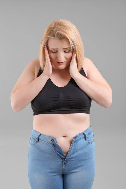 Sad overweight woman on grey background - Fotografie, Obrázek