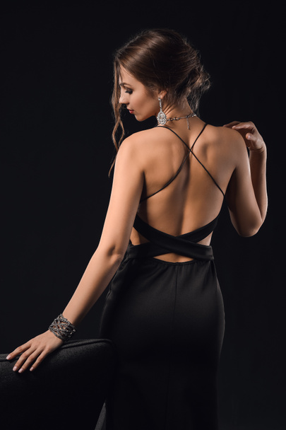 Young woman with beautiful jewellery on dark background - Valokuva, kuva