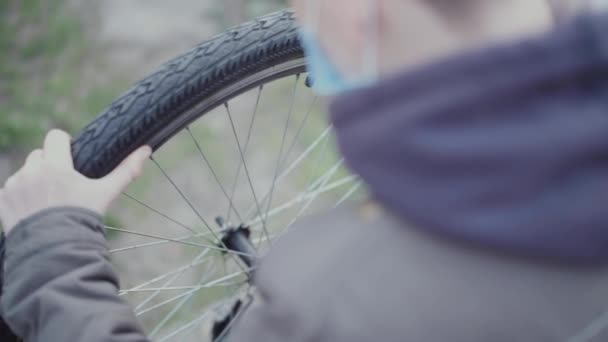 Teenager repariert sein Fahrrad in medizinischer Maske - Filmmaterial, Video