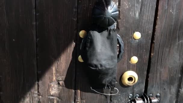zelfgemaakt medisch zwart masker hangend aan de deurknop in een huis. Er hangt een medisch masker aan de buitendeur. beschermend masker hangend aan een deurknop, quarantaine concept, coronavirus mirovach pandemie. - Video