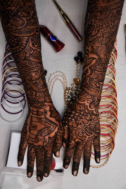 Frau Hand mit schwarzer Henna-Tätowierung auf Schmuck, indische Brautmädchenhand mit schwarzer Mehndi-Tätowierung - Foto, Bild