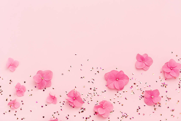 Весняна святкова рамка із золотого блискучого конфетті та рожевих квітів на копіювальному просторі
. - Фото, зображення