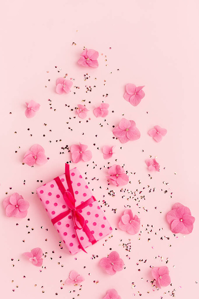 Gift box gold glitter confetti and flowers on pink holiday copy space. - Photo, Image