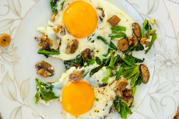 sunny side up eggs with mushrooms and spinach. Fresh eggs, omelet - Photo, Image