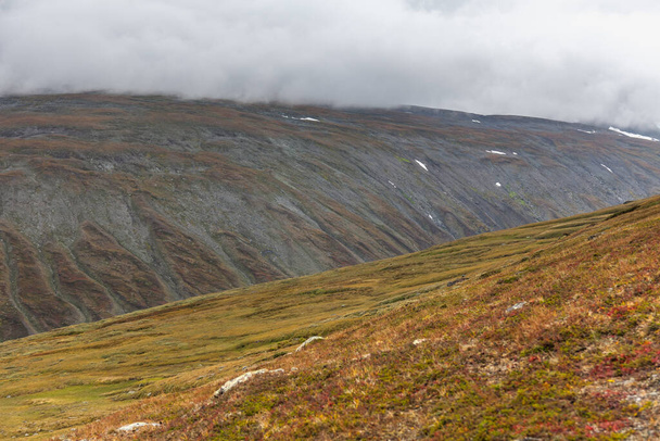 Krásná divoká příroda národního parku Sarek ve Švédsku Laponsko se zasněženými vrcholky hor, řekou a jezerem, břízkem a smrkovým lesem. Časné podzimní barvy v bouřlivém počasí. selektivní zaměření - Fotografie, Obrázek