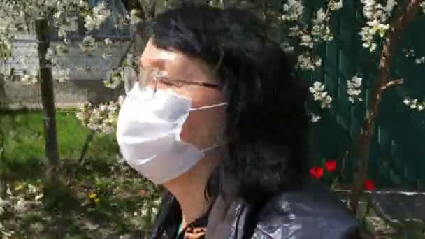 Senior actieve vrouw met medisch masker voor bescherming tegen het virus, rennend langs de weg op lege straat. Sport op quarantaine. Close-up en middelgroot plan. - Video