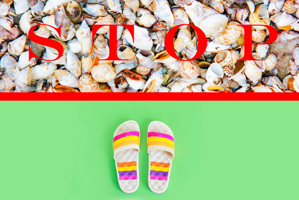 Strandpantoffeln Schiefertafeln vor roter Linie mit Muscheln und dem Wort Stop - Foto, Bild