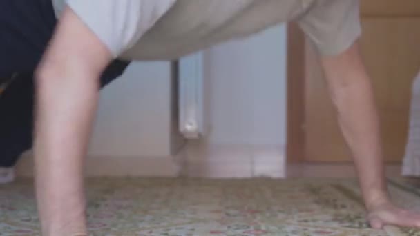 Középkorú férfi fekvőtámaszozik otthon. - Felvétel, videó