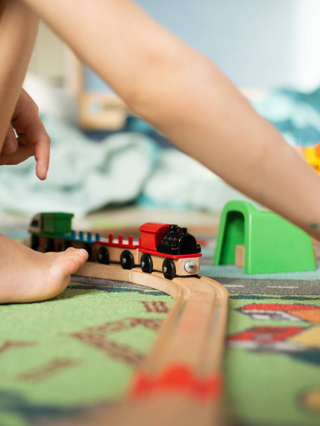 Closeup of toddler playing with toy train. games at home during self-isolation - Fotografie, Obrázek