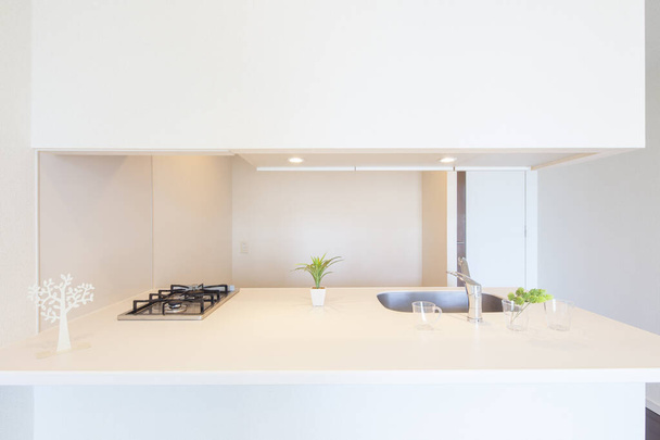 Una cucina luminosa e pulita in una stanza d'appartamento dai toni bianchi
 - Foto, immagini