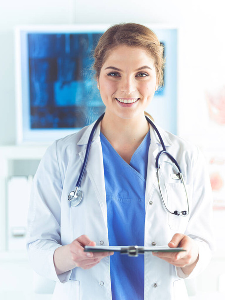 Woman doctor standing with folder at hospital - Φωτογραφία, εικόνα