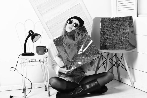 pretty sexy woman in sunglasses at colorful chair with package - 写真・画像