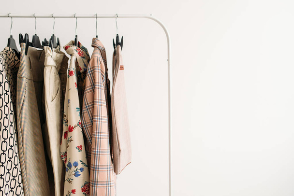 Rack with capsule clothes in beige colors closeup - 写真・画像