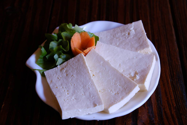 Georgische Nationalküche, Sulguni-Käse. Eingelegter georgischer Käse aus der Region Samegrelo. Suluguni hat eine saubere Sauermilch, mäßig salzigen Geschmack und Geruch, dichte, geschichtete, elastische Konsistenz. . Gericht auf dem Tisch. - Foto, Bild