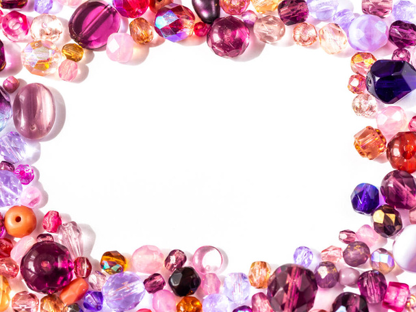 Игристые красочные бусины в фиолетовый, розовый, красный и фиолетовый цвет на белом фоне, скопировать пространство
 - Фото, изображение
