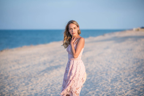 young woman in white dress on the beach - Foto, afbeelding