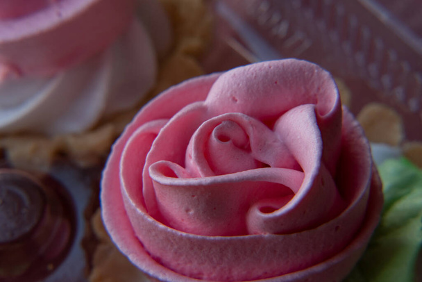 Torta kosár rózsa. Élelmiszer fotózás, desszert, Makro Photography. Fentről közelről frissen sült sütemény tele bogyós gandzsával, rózsaszín vajkrém cukormázzal, cukrászzsákból. - Fotó, kép