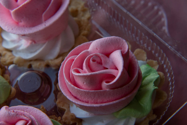 Cake Basket Rose. Food Photography, Dessert, Macro Photography. From above closeup of freshly baked cupcakes filled with berry ganache being decorated with pink buttercream frosting from pastry bag - Photo, Image