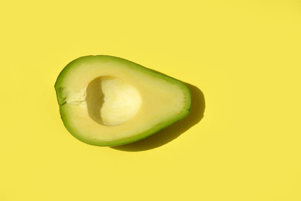 half of fresh avocado. Pop art design, creative concept of summer food. - Фото, зображення