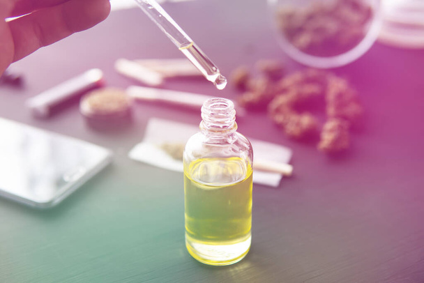 hemp product, Cannabis oil in pipette, medical marijuana concept, close up, natural herb, CBD cannabis OIL. light leaks color tones - Foto, Bild