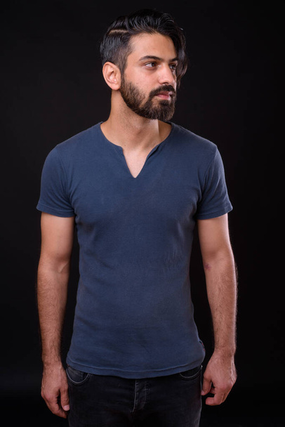 Plan studio d'un bel homme persan barbu sur fond noir - Photo, image