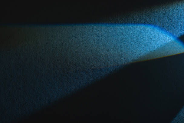 Lichtprisma mit Strahl auf blauem und schwarzem Texturhintergrund - Foto, Bild
